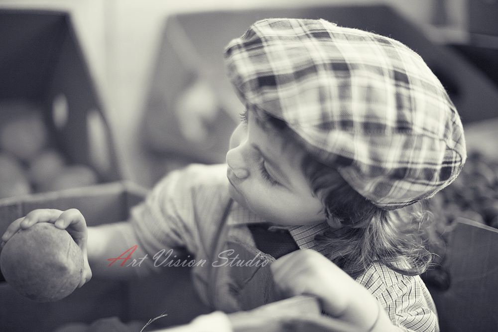 Stamford, CT lifestyle photographer - Black and white photo of a boy chosing peaches