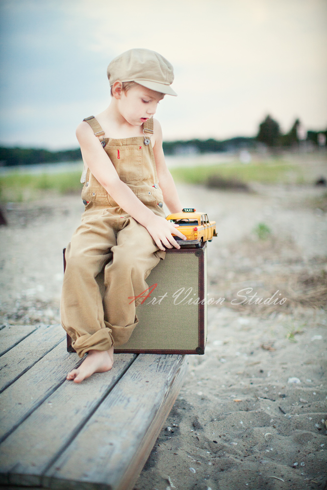 A boy playing with a  toy car - Vintage styled photography session for a toddler
